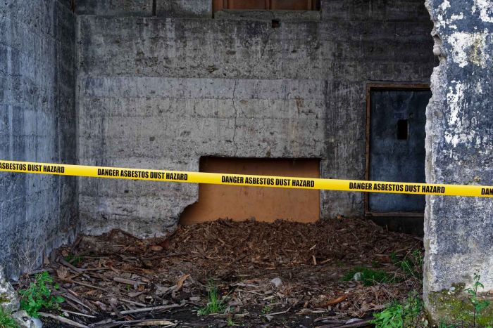 A yellow tape warns of the danger of asbestos dust.