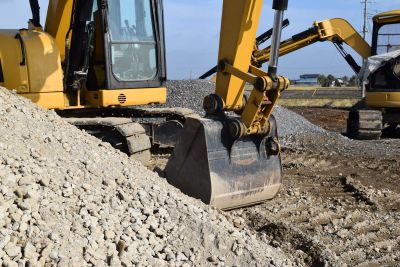 Large excavator digging up soil for land remediation.